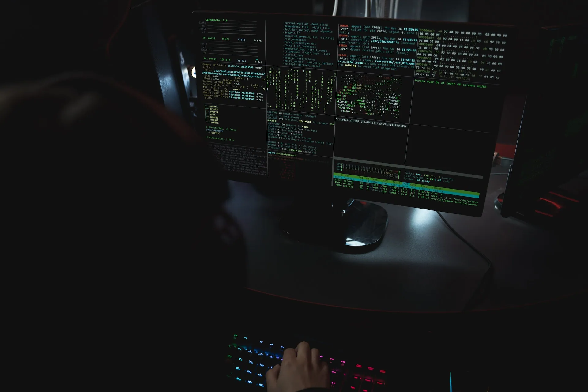 Person typing at a computer in a dark room
