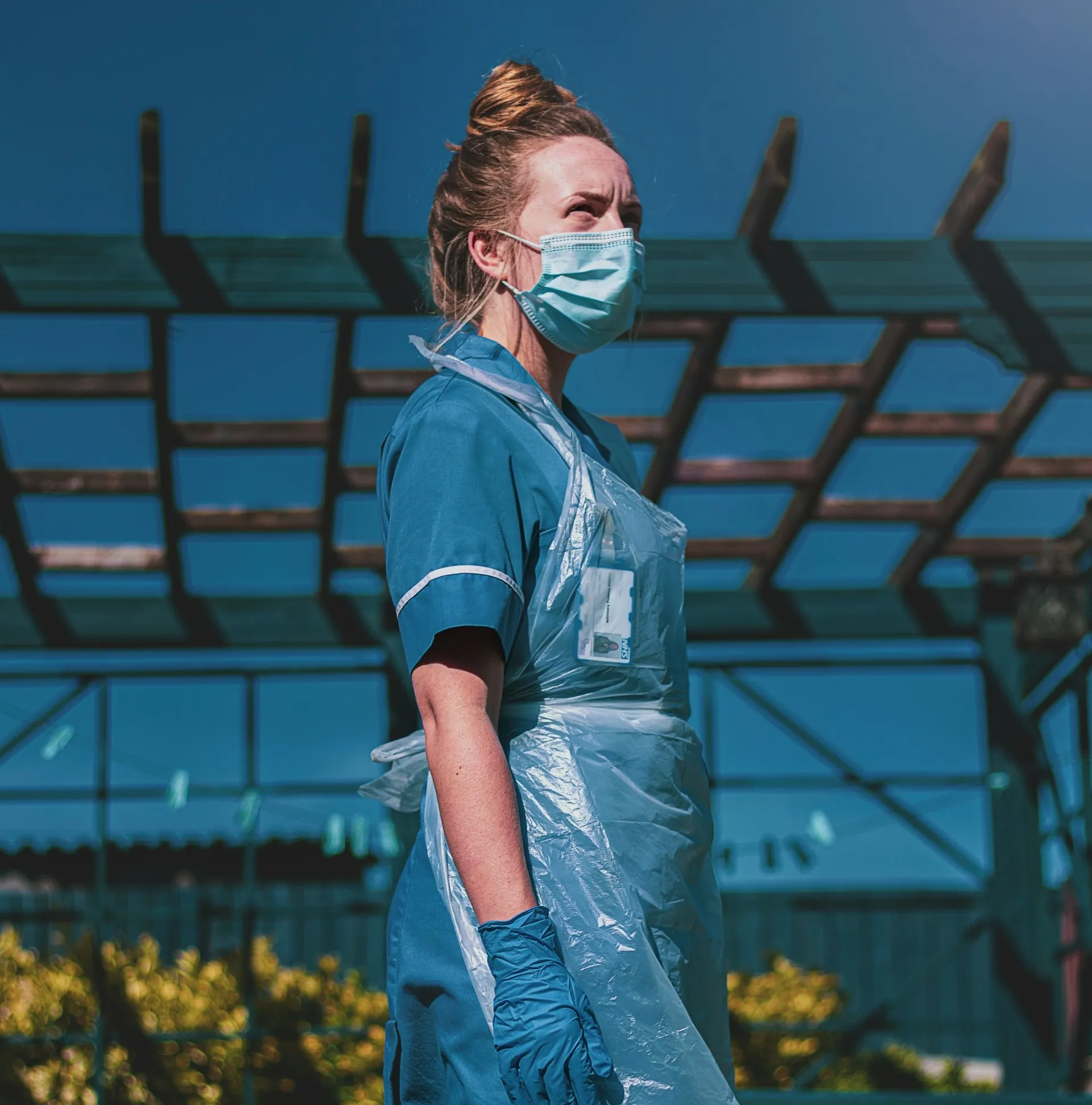 Healthcare worker in scrubs, face mask and apron